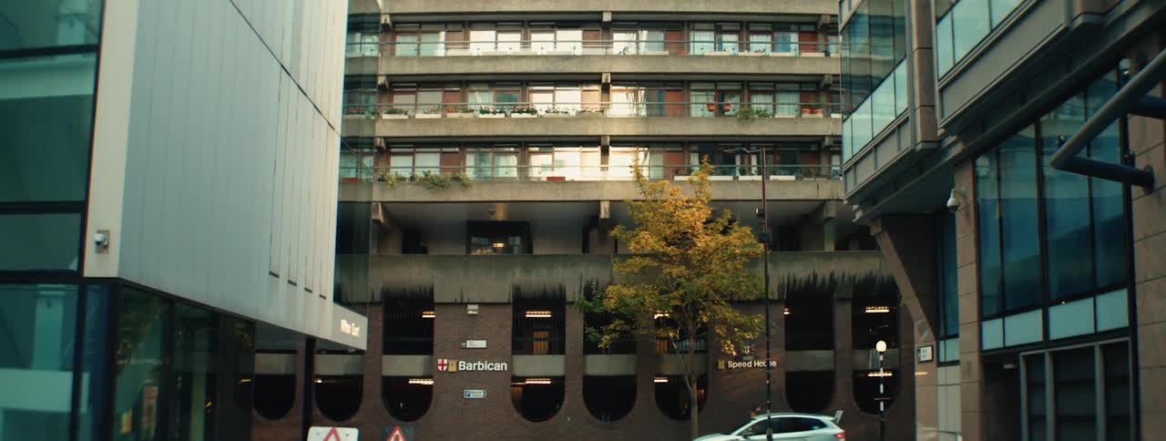 A view of the barbican estate in london with its distinctive brutalist architecture and a car driving through the complex