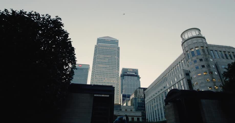 Upward view of urban and classical buildings against a cloudy sky