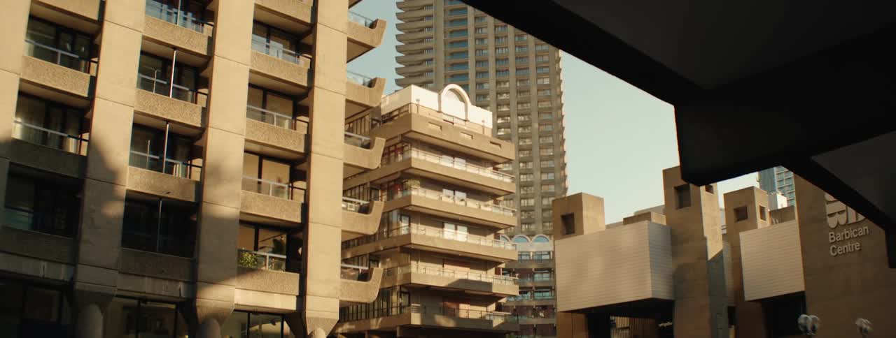 The barbican centres concrete architecture featuring tiered balconies and walkways is partially framed by dark beams