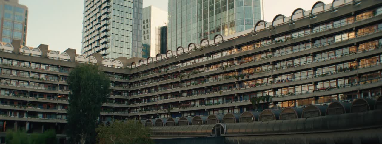 A striking contrast between the brutalist architecture of the barbican estate and the towering modern skyscrapers in londons cityscape