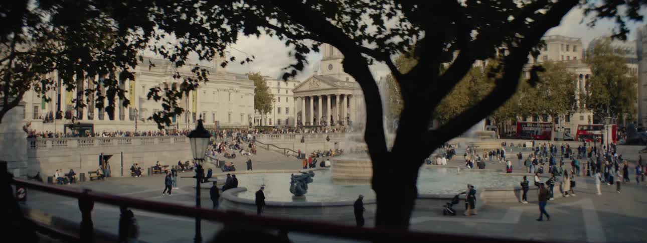 Crowd of people in a public square with a fountain in the center
