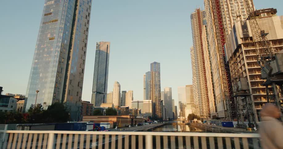 Moving view across a bridge overlooking buildings and skyscrapers in a city