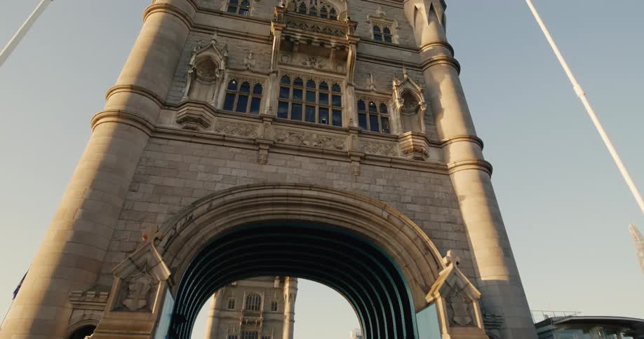 Tower bridge in london with gothic towers cars and pedestrians on a sunny day set against a city backdrop