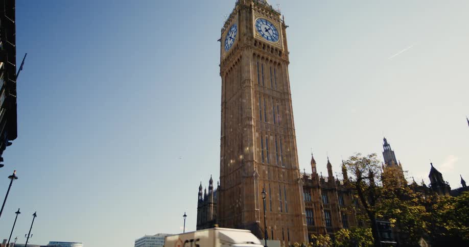Big bang clock next to a street with vehicle and pedestrian traffic