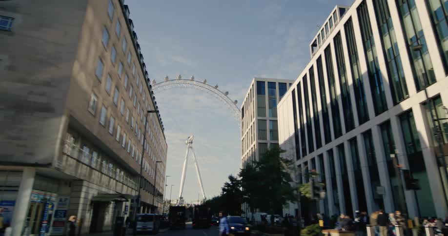 City of london with buildings and pedestrians and a ferris wheel in the background