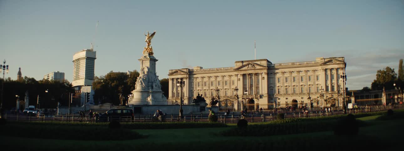 Classical statue in a square and people walking and cycling around it