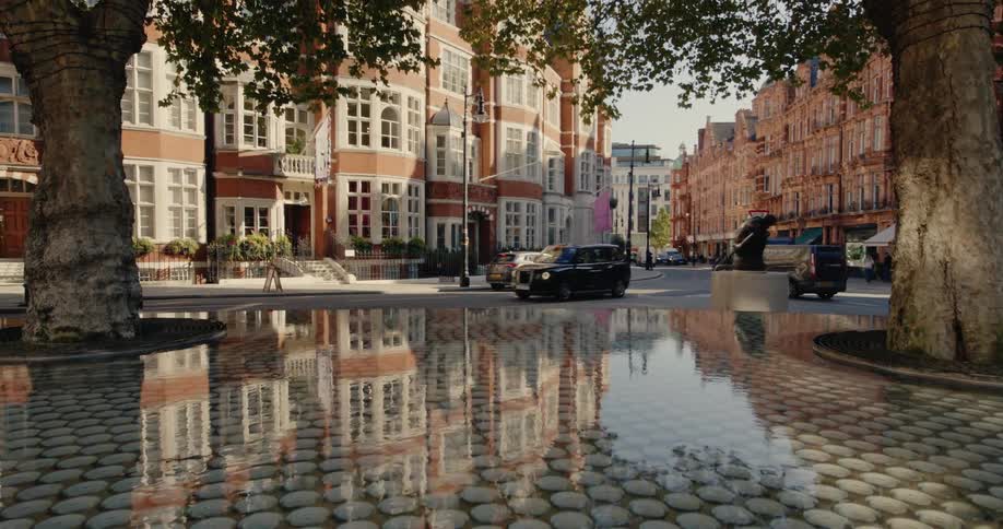 Landscape of an urban city with classical buildings and a square with water and trees in the foreground