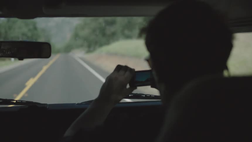 People drive in a vehicle down a rural road