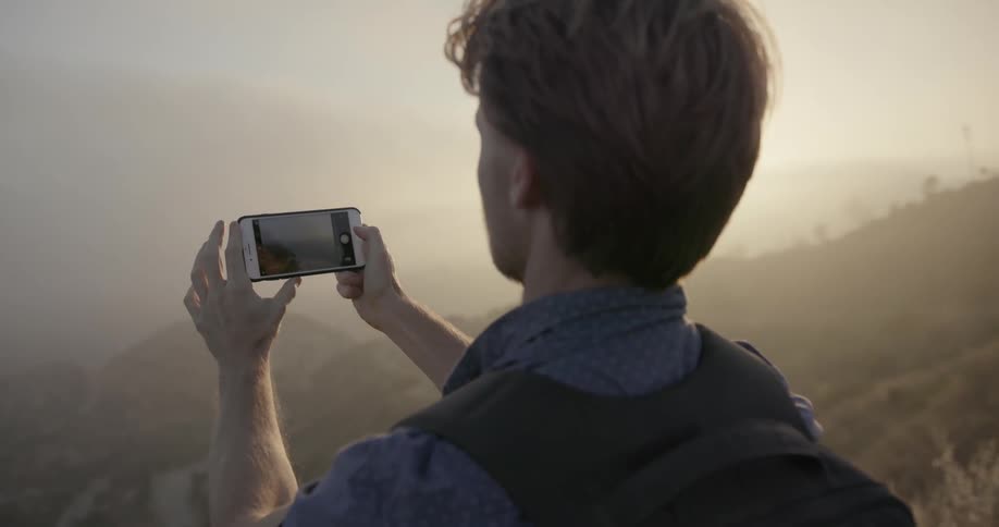 A man takes a photograph with his phone