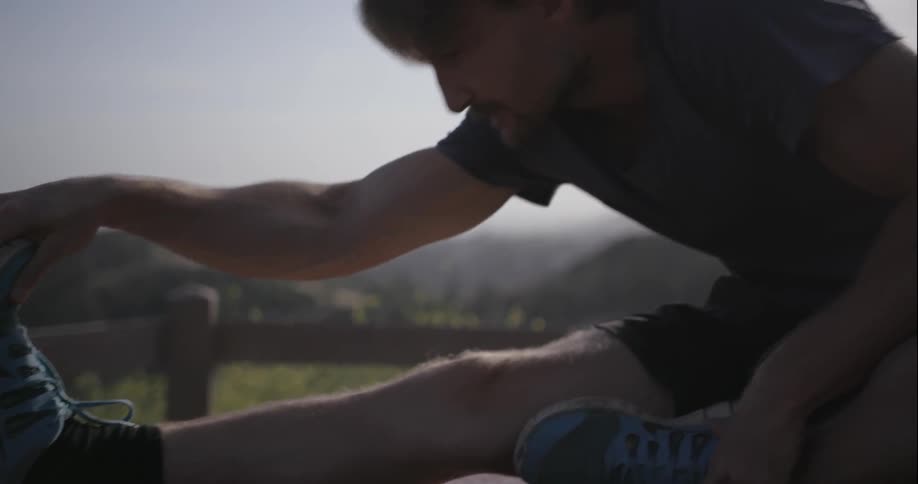 A man is stretching before hiking