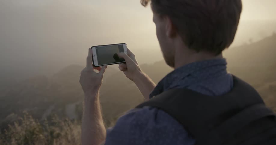 A man takes a photograph with his phone