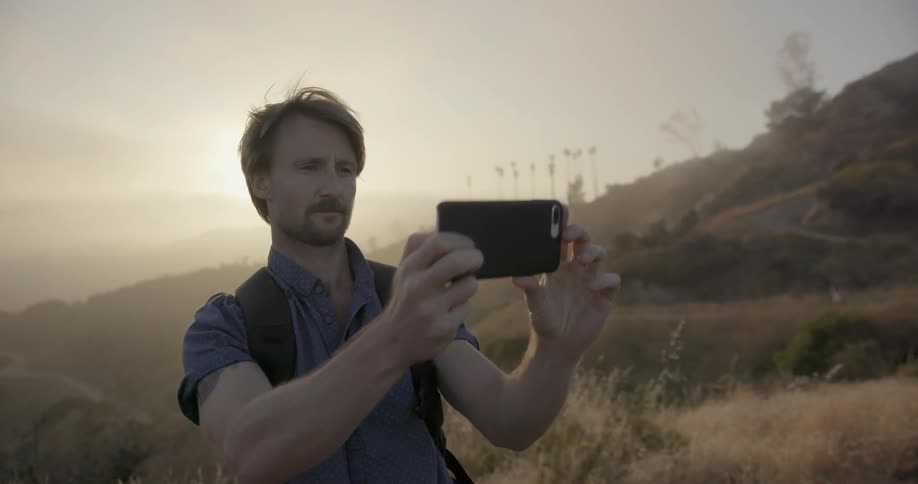A man takes a photograph with his phone