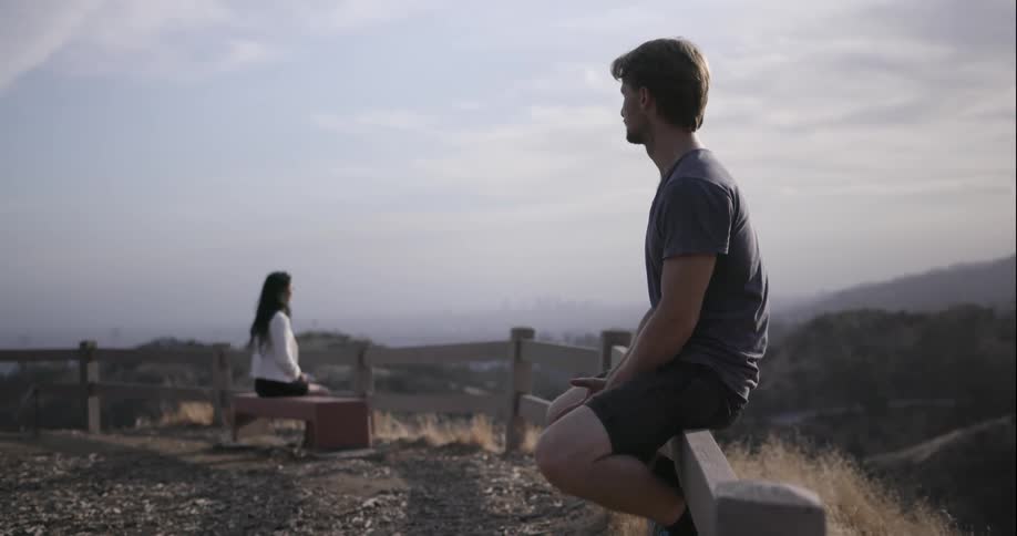 A man and woman sit on opposite benches