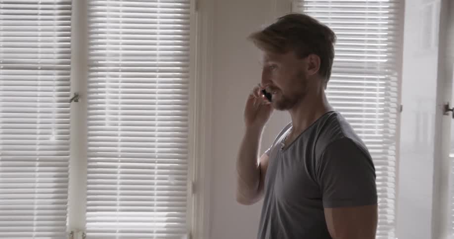 A man holds a coffee mug and talks on the phone