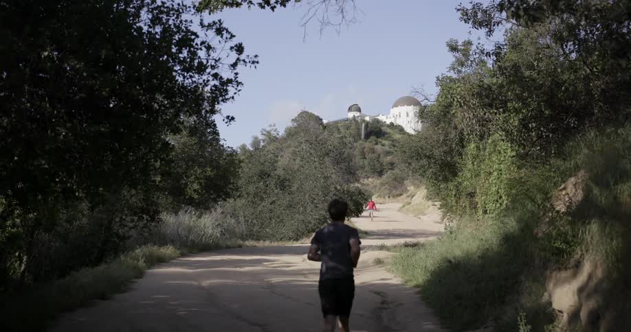 People are jogging down a trail uphill