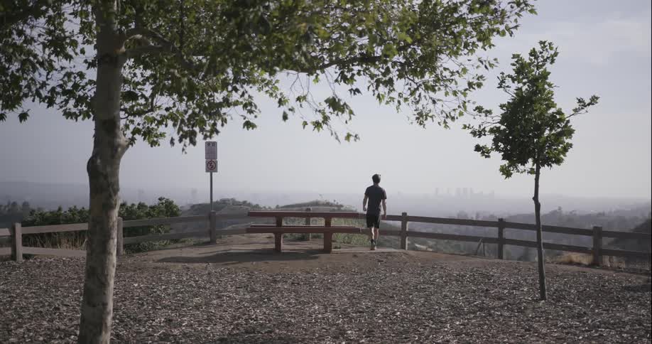 Man jogs towards a wooden fence