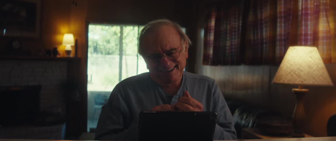 A man smiles and talks with someone on his tablet