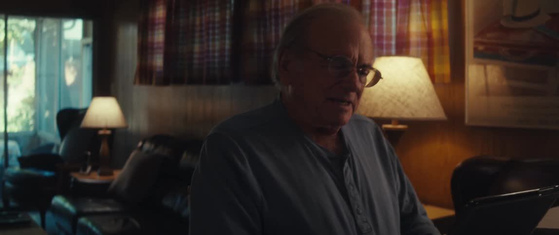 Elderly man sitting talking and interacting with a tablet