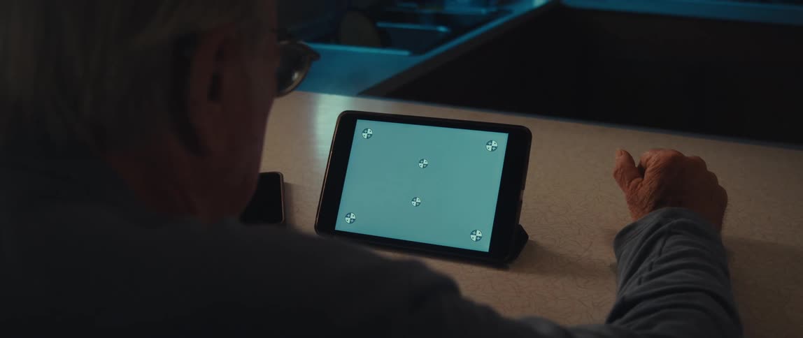 An elderly mans hand interacting with a tablet screen