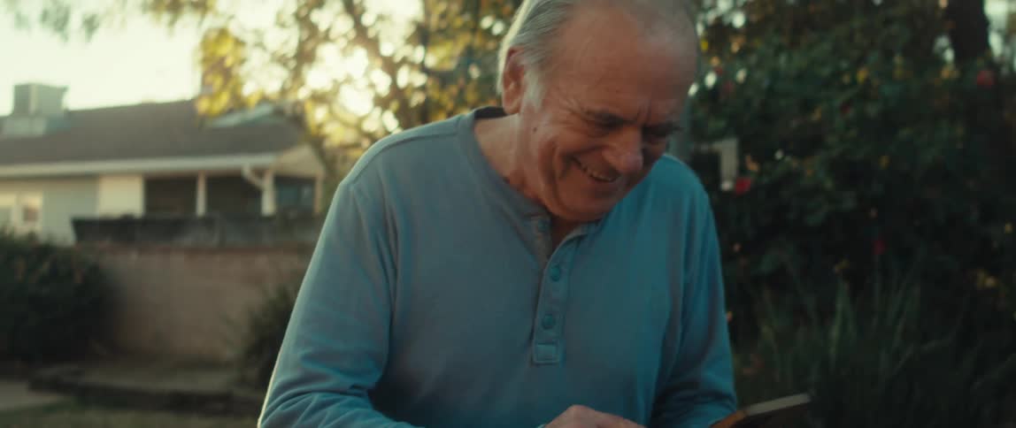 A man walks in his yard while using his cell phone