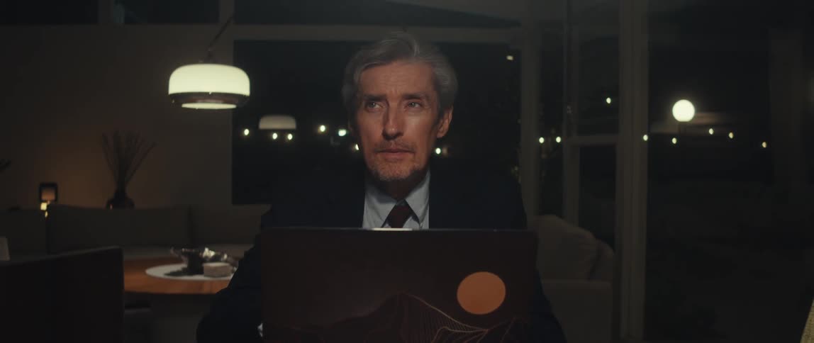 Man sitting in front of a laptop in a room