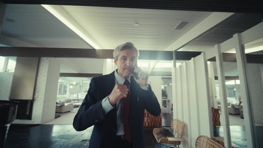 Man in suit indoors on a call on smartphone