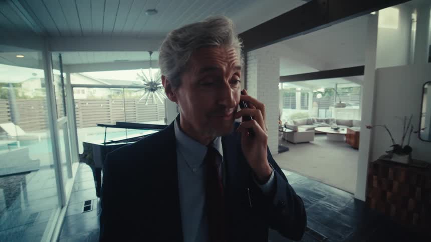 Man standing in an indoor space on a call via smartphone