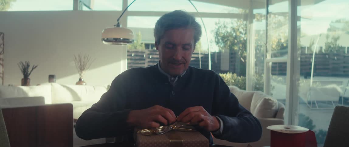 Time-lapse of man wrapping a bow around a gift and proudly displaying it