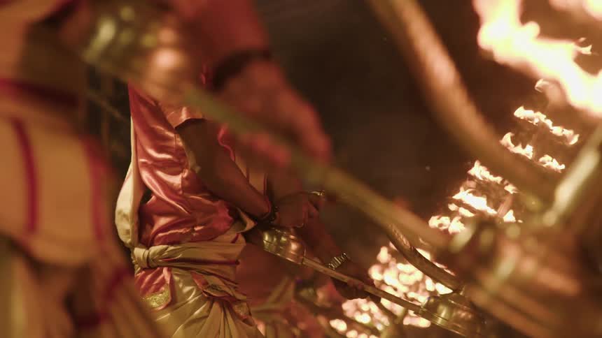 Two people holding candlesticks filled with flames back and forth