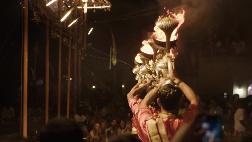 Crowd of people watching a group performing holding chalices of fire