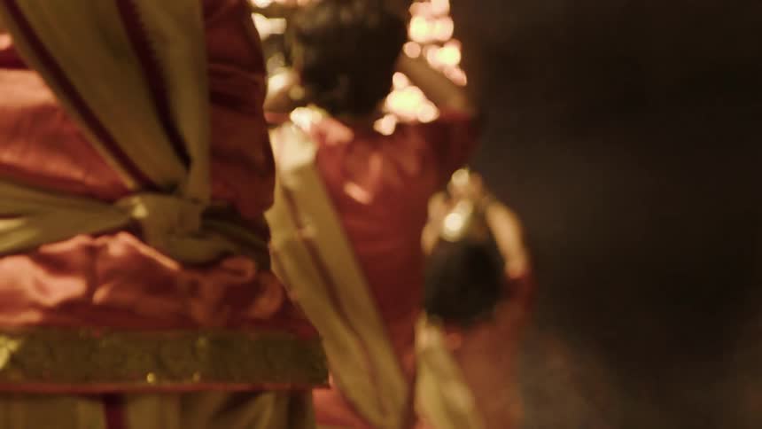 People holding a chalice with a fire in a ceremony at night