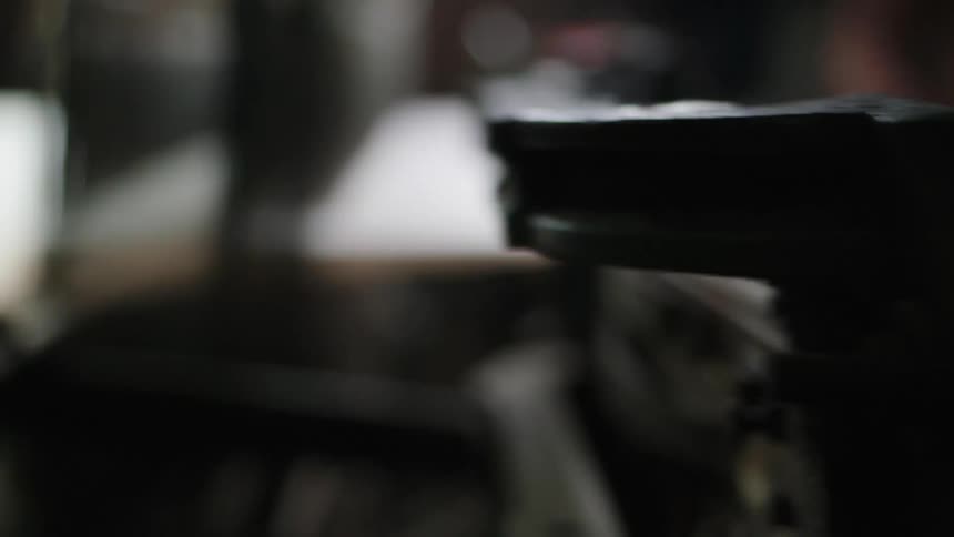 A close up shot shows a loom in operation with the focus on the moving parts and the fabric being woven
