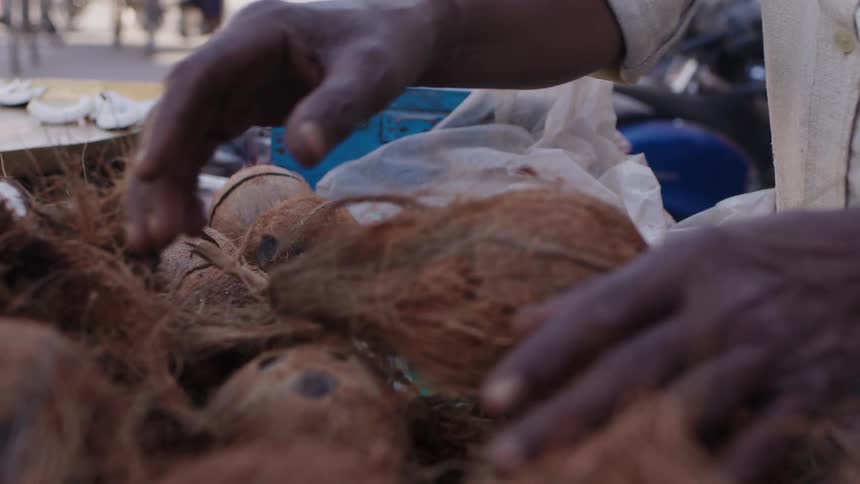 A close up clip of a person selling coconut