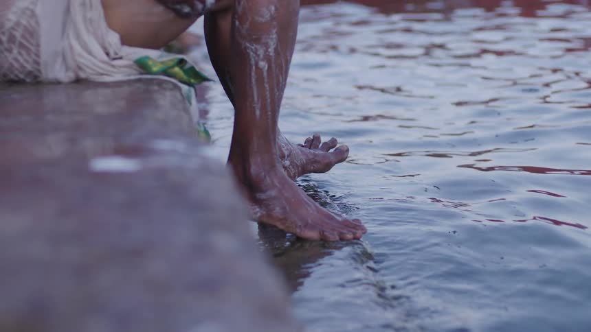 Legs of a person in a river taking a bath