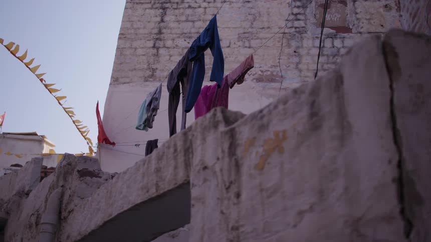 Outside view of clotheslines with clothes and flags in an archaic structure