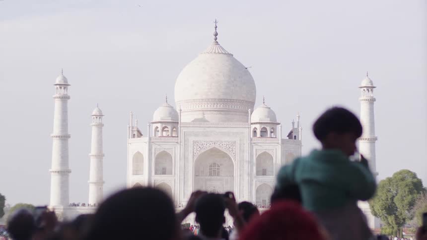 A clip of people standing in front of a mosque