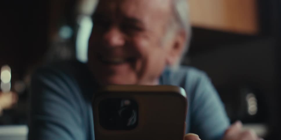 Man sitting inside his home and talking to someone on his phone