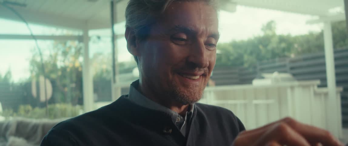 Happy man finishing the bow on a gift