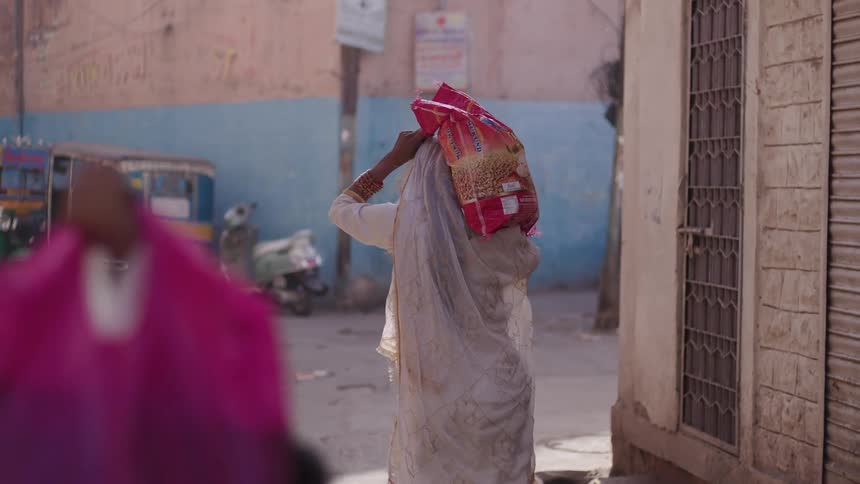 People carrying bags on their shoulders in an underdeveloped country
