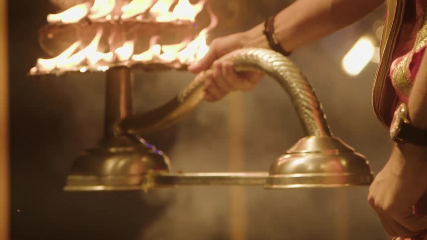 A performer is waving around a lamp covered in fire
