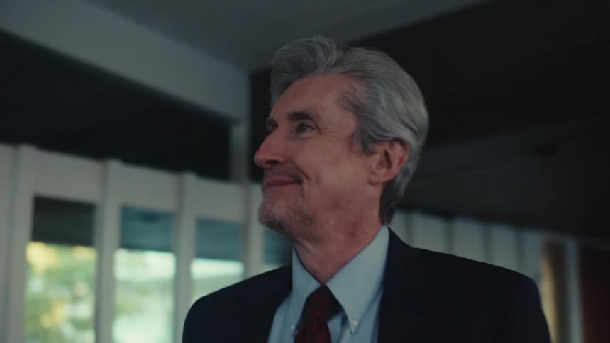 A clip of an elderly man smiling indoor