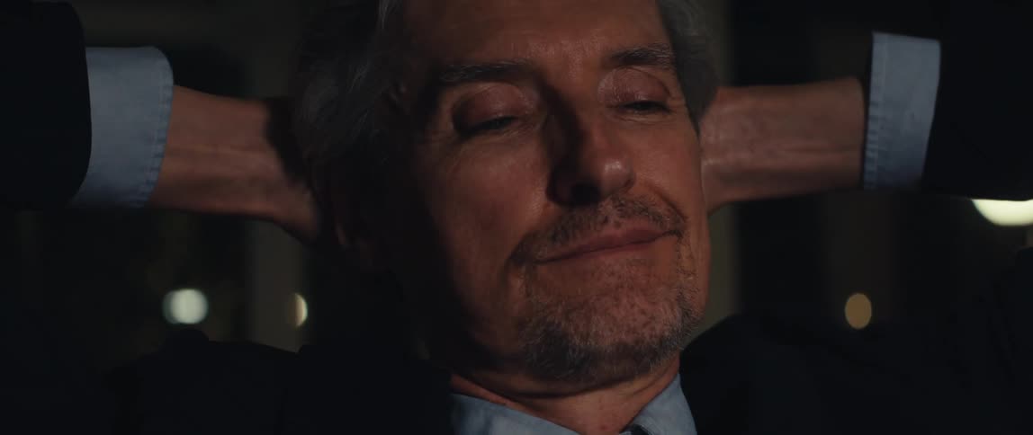 Portrait of a man with his hands behind his head and an unhappy facial expression