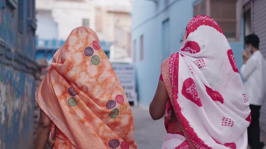 Two women walk down the alley