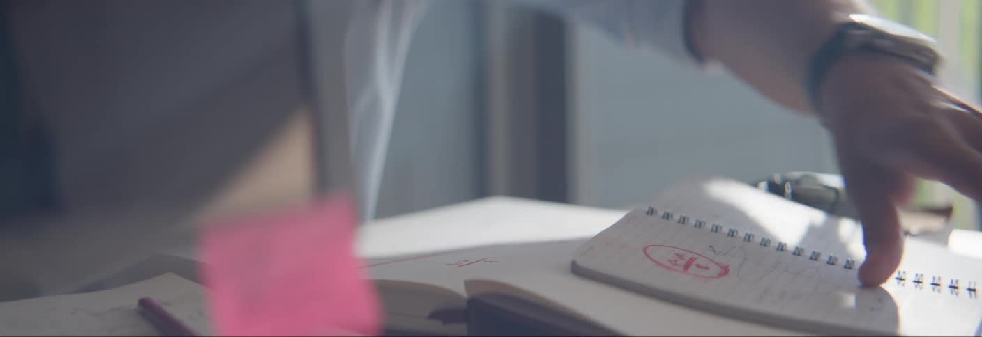 Hands of a person turning the page in a notebook on the table