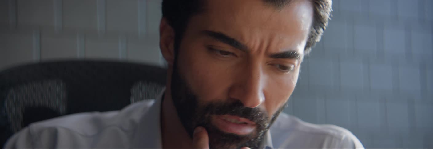 The face of a young bearded man who is looking at the water in front of him with great attention and moving his head from side to side