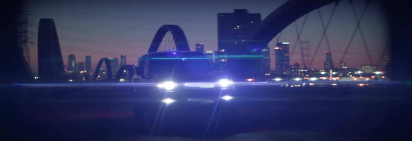 Car traveling across a bridge at night