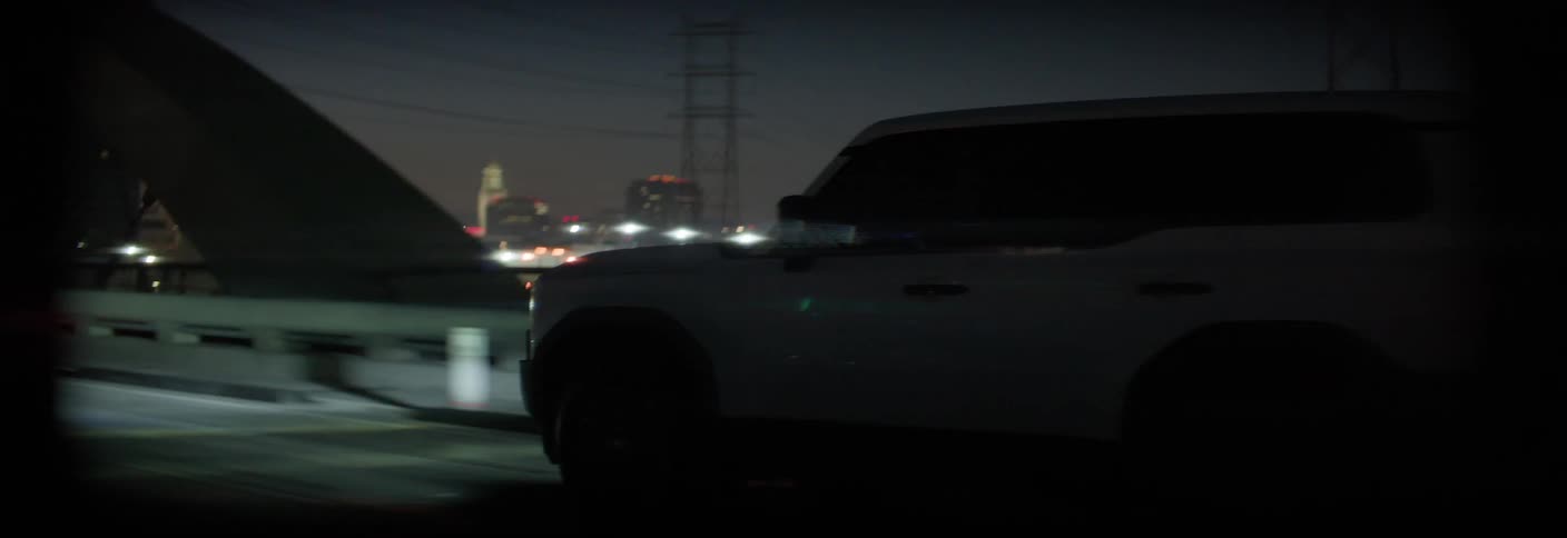 White car crossing a bridge at night
