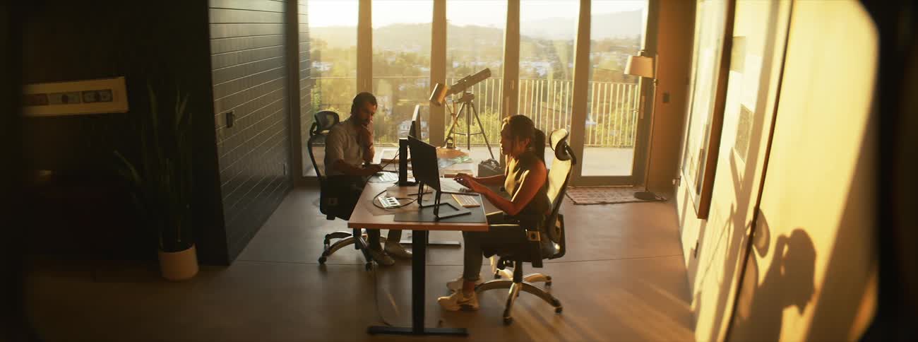Man and woman sitting at a table in an office environment