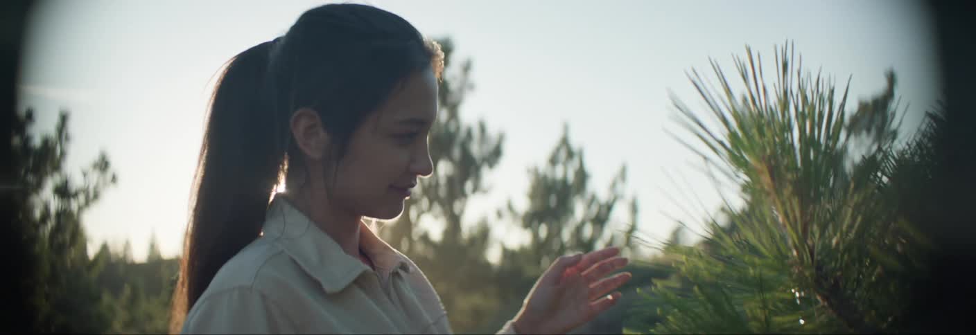 Woman looking at a green plant outdoors