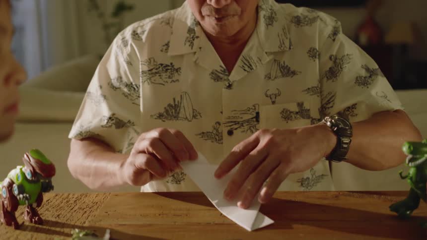 Man sitting folding a sheet of paper